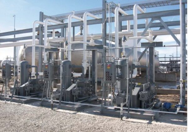 Liquid Transfer Solutions equipment with pipes, panels, and tanks installed outdoors on a gravel surface.